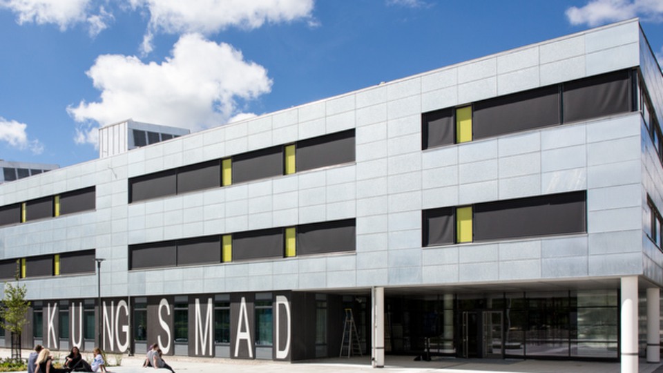 Kungsmadskolan utifrån. Två elever sitter utanför skolan. 